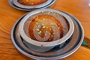 Turkish dessert kunefe, kunafa, kadayif with pistachio powder and cheese, served hot, very sweet photo