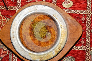 Turkish dessert kunefe with pistachio powder. Kunafa, kadayif with pistachio powder and cheese hot