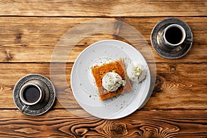 Turkish dessert kunefe served with ice cream on wooden background