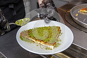 Turkish dessert kÃ¼nefe, kÃ¼nefe, peanut powder and cheese kadayif, served hot, is very sweet. Turkish traditional dessert. Chef