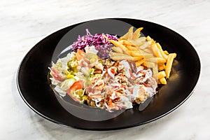 Turkish donner kebab with fries and salad on plate