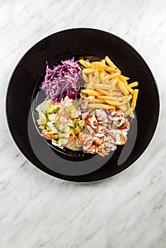 Turkish donner kebab with fries and salad on plate