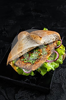 Turkish fish sandwich with grilled mackerel fillet Balik Ekmek. Black background. Top view