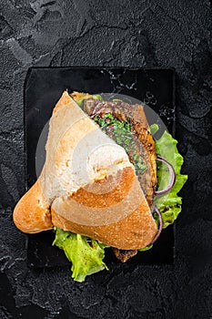 Turkish fish sandwich with grilled mackerel fillet Balik Ekmek. Black background. Top view
