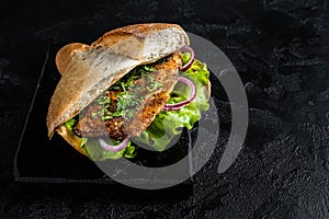 Turkish fish sandwich with grilled mackerel fillet Balik Ekmek. Black background. Top view