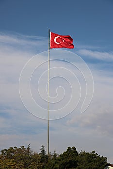 Turkish flag, flag pole, blue sky.