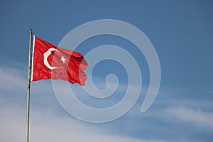 Turkish flag, flag pole, blue sky.