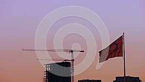 Turkish flag slow motion waving front of construction / building at sunset