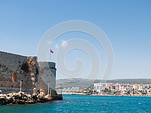 Turkish flag on the top of Maiden`s castle or Kizkalesi or Deniz kalesi and view of sea and Kizkalesi town