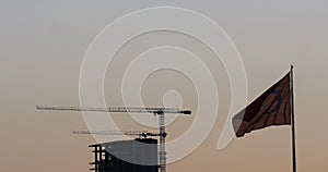 Turkish flag waving front of construction / building at sunset