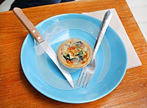 Turkish flat bread with cheese and spinach topping served on a plate.