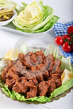 Turkish Food Cig Kofte with lemon, lettuce and parsley on silver plate
