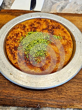 Arabian sweet during Ramadan.kanafeh traditional middle east Arabic food restaurant dessert on a white dish plate