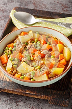 Turkish Kiymali bezelye yemegi Peas with minced meat and vegetables stew closeup on the plate. Vertical