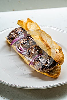 Turkish Kofte Ekmek / Meatball Sandwich with Red Onions. Traditional Fast Food from Turkey