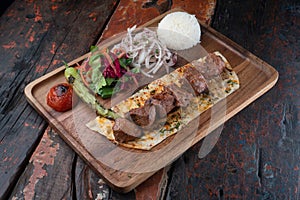 Turkish lamb sis kebab with rice and vegetables on rustic wooden table