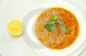 Turkish lentil soup on a plate with mint and lemon