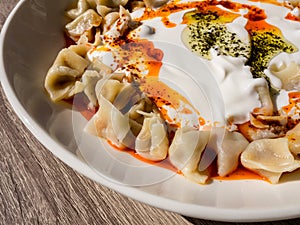 Turkish Manti with red pepper, tomato sauce, yogurt and mint. Plate of traditional Turkish food. Top view photo