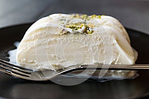 Turkish Maras Vanilla Ice Cream with Pistachio Powder Served Portion in Black Plate.