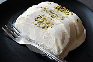 Turkish Maras Vanilla Ice Cream with Pistachio Powder Served Portion in Black Plate.
