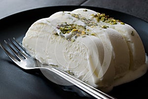 Turkish Maras Vanilla Ice Cream with Pistachio Powder Served Portion in Black Plate.