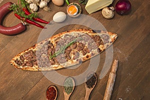 Turkish pide with cubed meat and cheese on wooden background