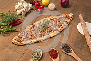 Turkish pide with cubed meat and cheese on wooden background