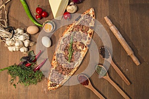 Turkish pide with cubed meat on wooden background