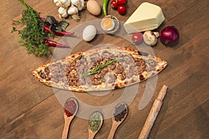 Turkish pide with cubed meat on wooden background