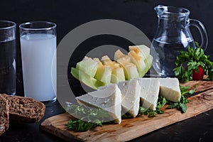 Turkish Raki with water on table with sliced melon and appetizer, traditional Turkish alcohol known as Raki, chill with
