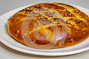 Turkish ramadan bread, pita bread on white plate with sesames and black seeds