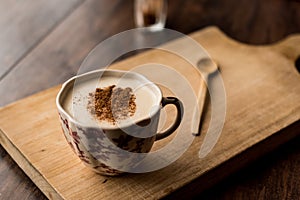 Turkish Salep with cinnamon sticks on a wooden surface.