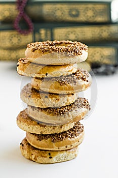 Turkish Sesame Rings Kandil Simidi stacked on the white surface In front of the blurred scripture