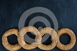 Turkish simit bagel dusted with sesame seeds on a black background