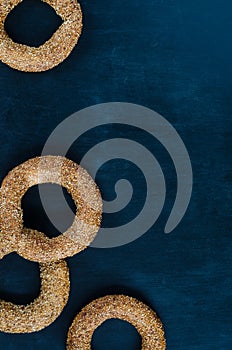 Turkish simit bagel dusted with sesame seeds on a black background