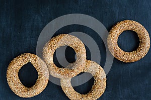 Turkish simit bagel dusted with sesame seeds on a black background