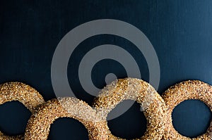 Turkish simit bagel dusted with sesame seeds on a black background