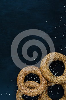 Turkish simit bagel dusted with sesame seeds on a black background