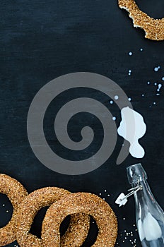 Turkish simit bagel and splashes of milk on a black background