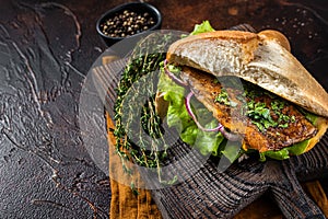 Turkish Street Food Balik Ekmek, fish sandwich with grilled mackerel fillet in a bun. Dark background. Top view. Copy