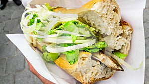 Turkish street food fish bread with onions and greens / Balik Ekmek