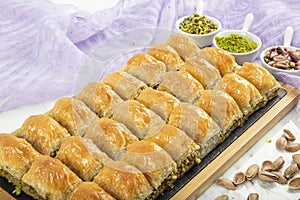 Turkish style pistachio baklava presentation and service. Baklava on a marble floor photo