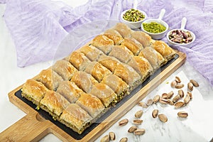 Turkish style pistachio baklava presentation and service. Baklava on a marble floor photo