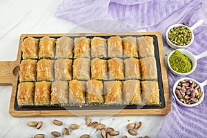 Turkish style pistachio baklava presentation and service. Baklava on a marble floor photo