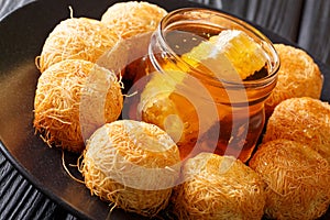 Turkish sweets balls kadaif with fresh honey close-up. horizontal