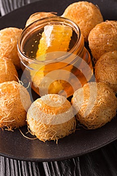 Turkish sweets balls kadaif with fresh honey close-up. Vertical