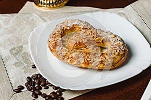 Turkish sweets - sweet bagel with filling sprinkled with pieces of nuts.