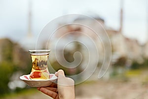 Turkish Tea Drink In Traditional Glass Cup In Hand