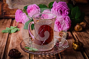 Turkish tea in a glass cup and dried dates fruits on wooden background. Ramadan food. Selective focus