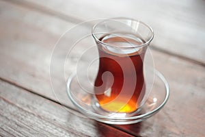 Turkish tea in traditional glass on wooden background. Selective focus.